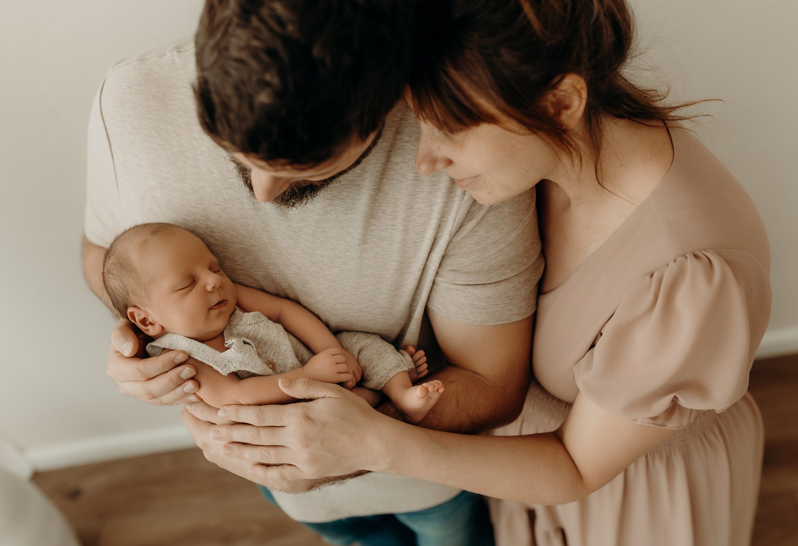 Mama Papa und Baby aneinander gelehnt beim Neugeborenen Shooting